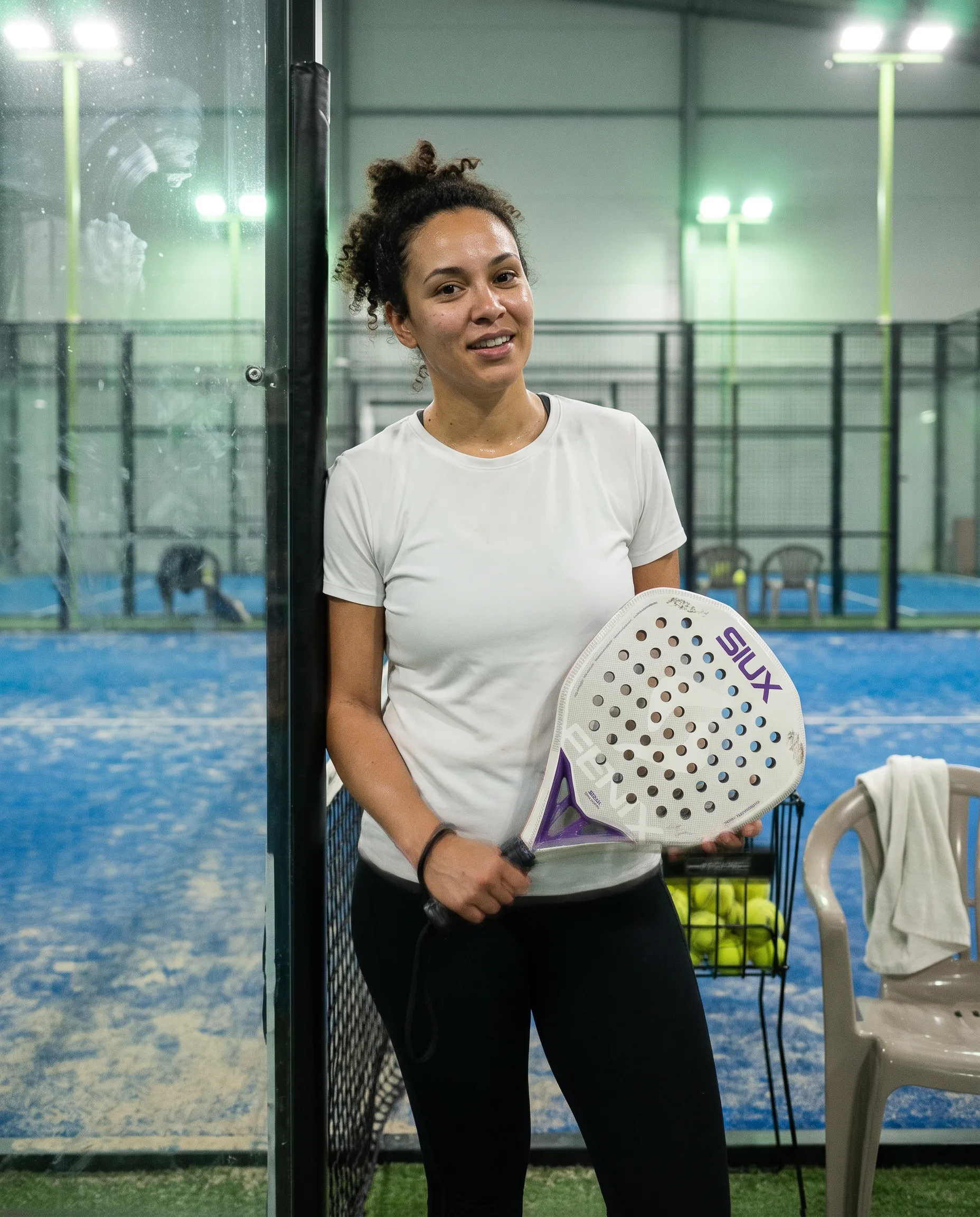 Player leaning on the net post indoors holding the Siux Fenix Pro SE 2.0