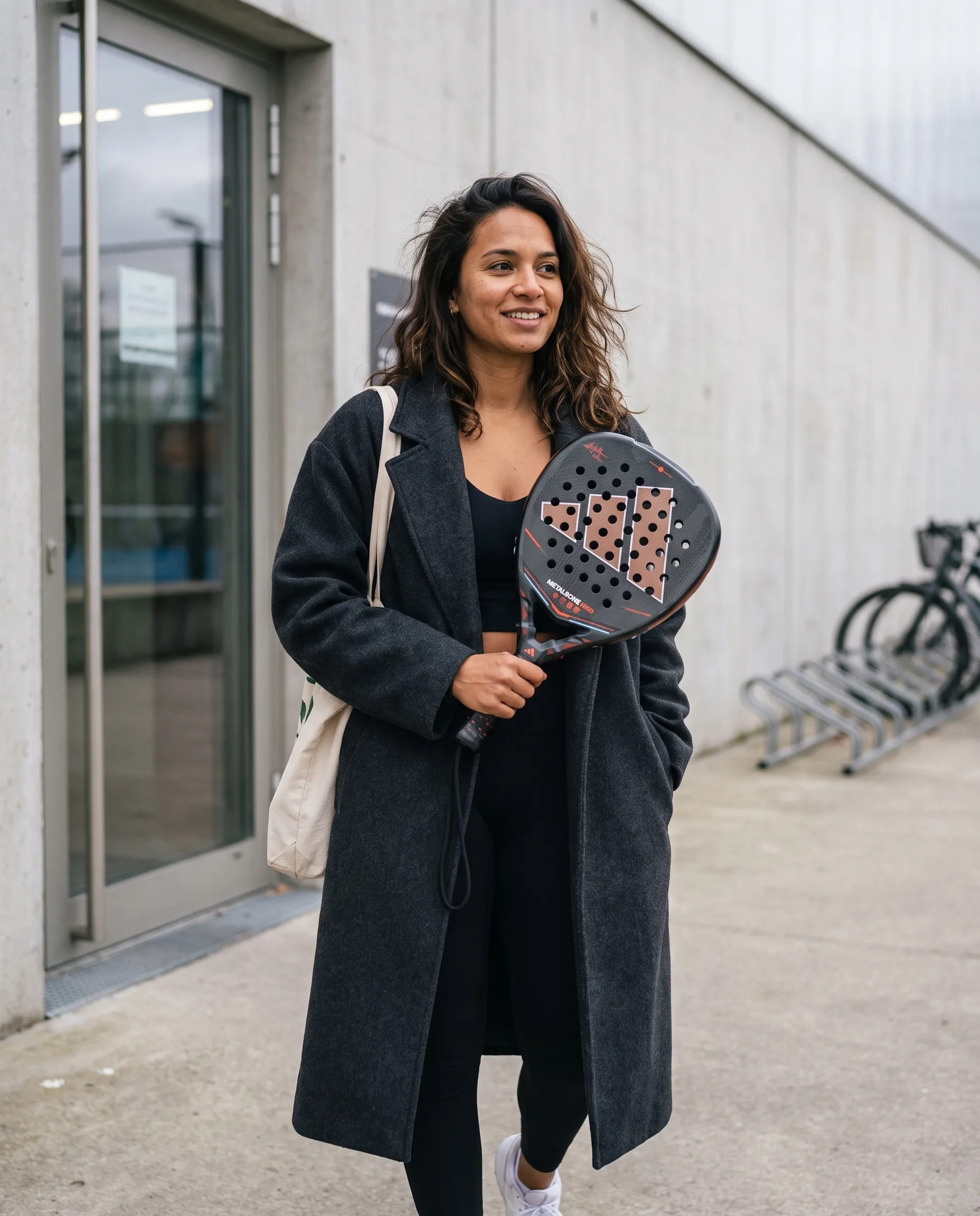 Player in a wool coat outside the club holding the Adidas Metalbone HRD